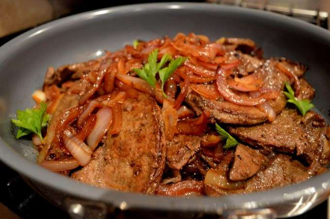Pedaços de fígado frito com cebola e pimentão fresco em um prato. delicioso  prato saudável.